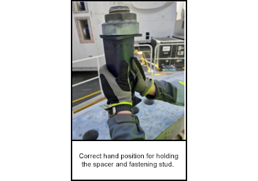 Correct hand position for holding the spacer and fastening stud. 