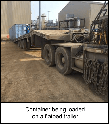 Container being loaded on a flatbed trailer