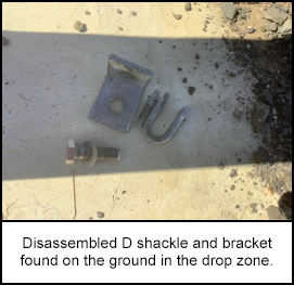 Disassembled D shackle and bracket found on the ground in the drop zone