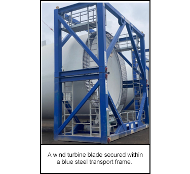 A wind turbine blade secured within a blue steel transport frame.