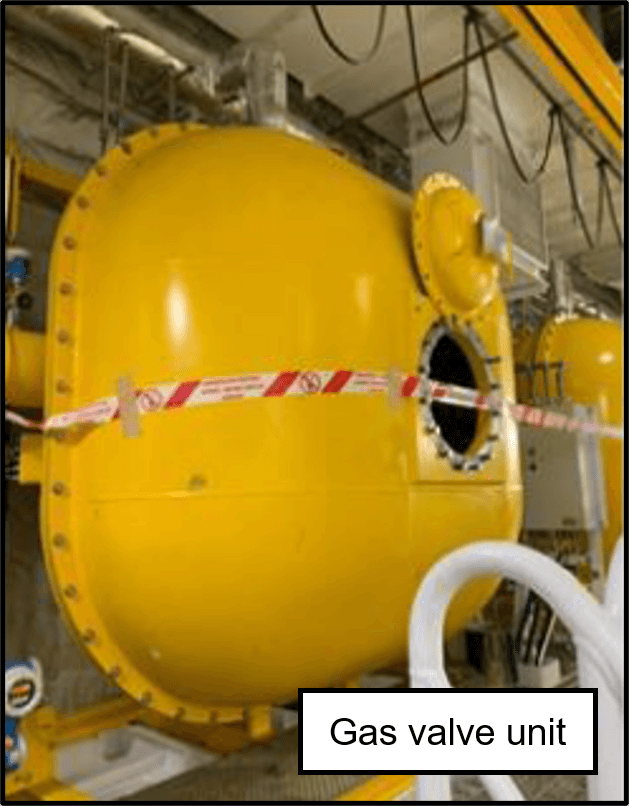 The opened, yellow gas valve unit. Red and white protective tape is wrapped around the gas valve unit. 