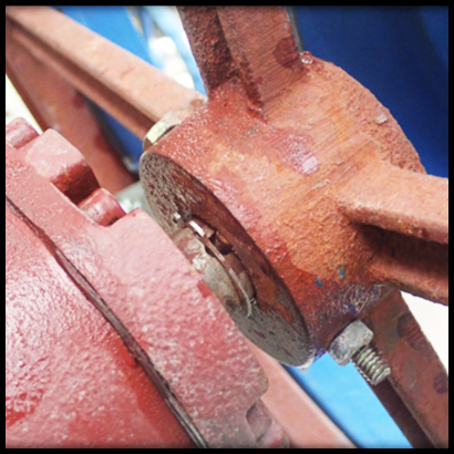 Close-up of a chain wheel with nut and bolt visible and holding wheel in place.