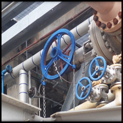 A blue chain wheel and chain secured in place, surrounded by pipework