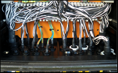 配电盘底部的电缆密封套畅通无阻，装有许多电缆。 