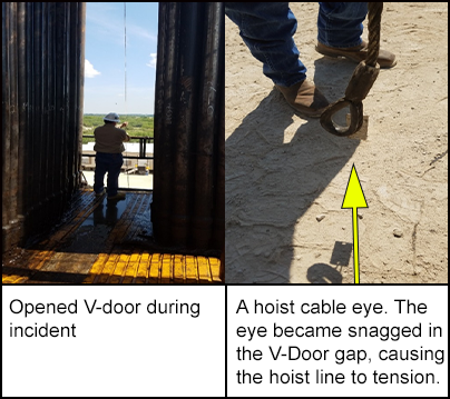 A worker stood in the opened V-door. On the ground, a worker is stood next to a hoist cable eye which had been snagged in the V-door gap. 