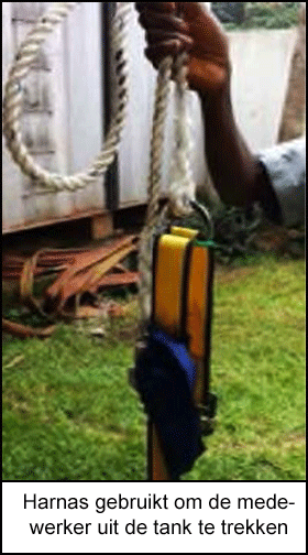Een medewerker houdt het harnas omhoog dat werd gebruikt om de medewerker uit de tank te trekken.