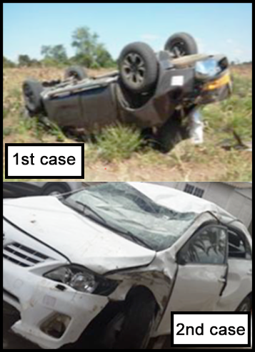 Two cars. A grey car is overturned with significant dents to the body. A white car has smashed front windows and dents around a front wheel and roof.