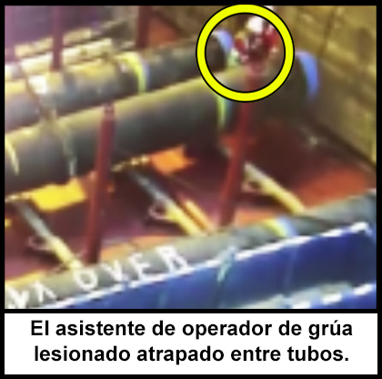 El asistente de operador de grúa atrapado entre dos tubos grandes.