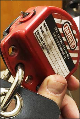 A worker holding the red lock that was attached to the tag.