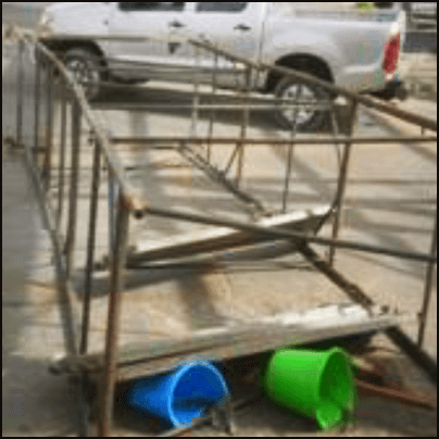 The fallen scaffolding. Two damaged buckets are underneath the scaffolding.